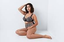 Woman in bra leaning against door frame